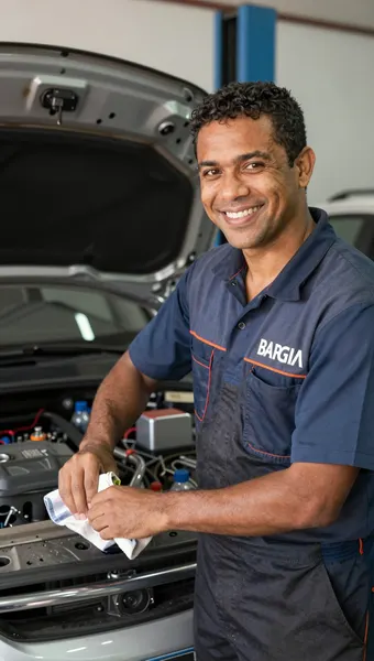 Mecânico sorrindo ao lado do carro na oficina